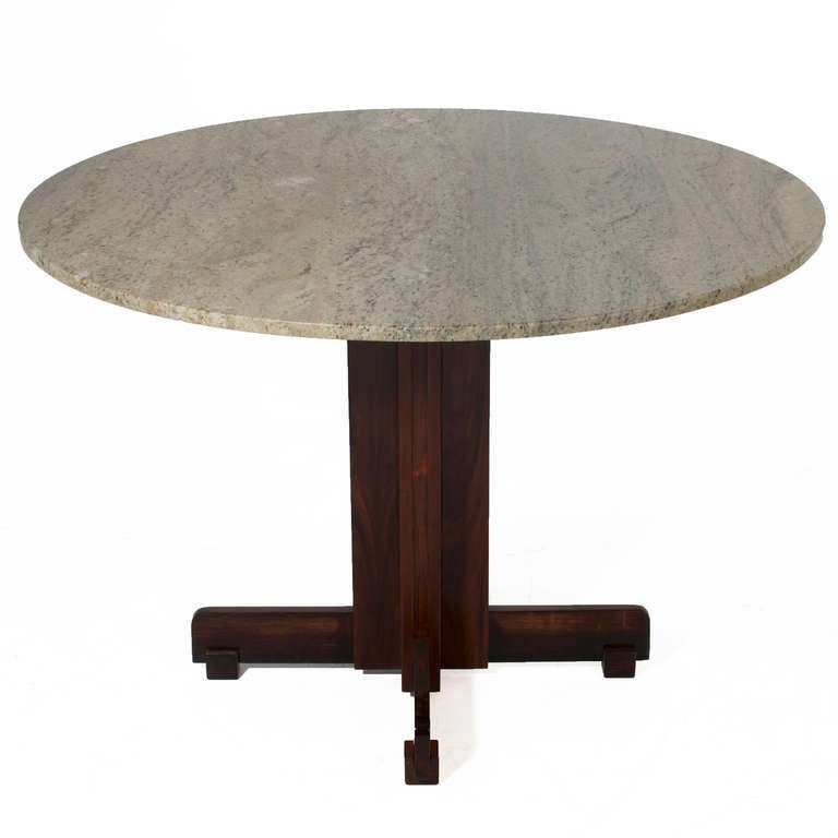 Une table de salle à manger ronde en granit avec un socle unique en palissandre brésilien. Le granit est d'un beau vert gris avec des taches foncées. La base peut également accueillir un morceau de granit ou de marbre de taille différente si
