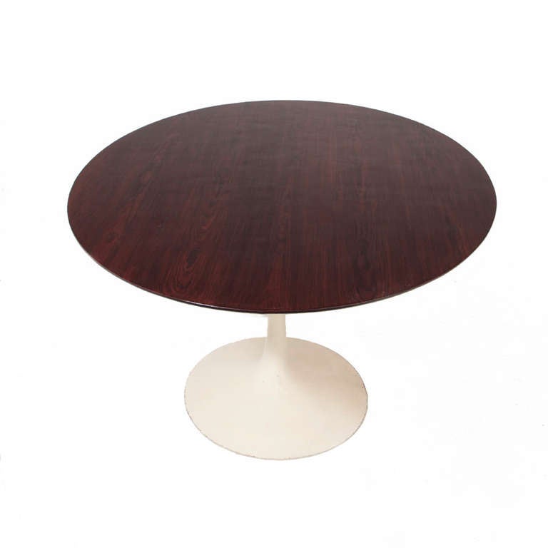 A beautiful example of the classic Tulip dining table design by Eero Saarinen for Knoll with sculpted white enamel base and oval Rosewood top. The base can be re-powdered coated to be perfectly bright white; we chose to leave it in its original