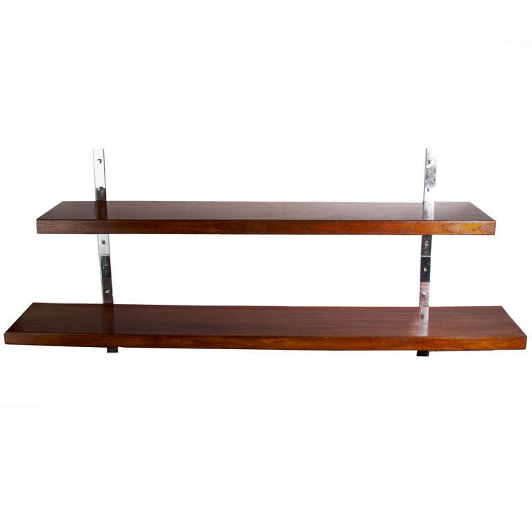 A set of two hanging  shelves in different lengths on chrome flat bar wall mounts. The placement on the wall can be staggered and easily adjusted with the versatile wall mounts. Upper shelf is complimented with square chrome headed screws.  They are