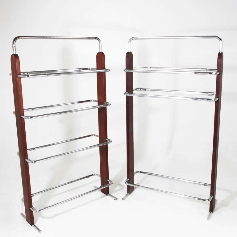 A beautiful pair of bookshelves from Brazil in solid Baruna wood with chrome frames and inset glass shelves. The Baruna has been refinished and oiled, and one of them has one less shelf. The shelves are theoretically adjustable but are difficult to