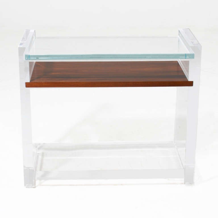 A single side table or end table in lucite with top shelf in glass and lower shelf in Rosewood. 

Many pieces are stored in our warehouse, so please click on CONTACT DEALER under our logo below to find out if the pieces you are interested in