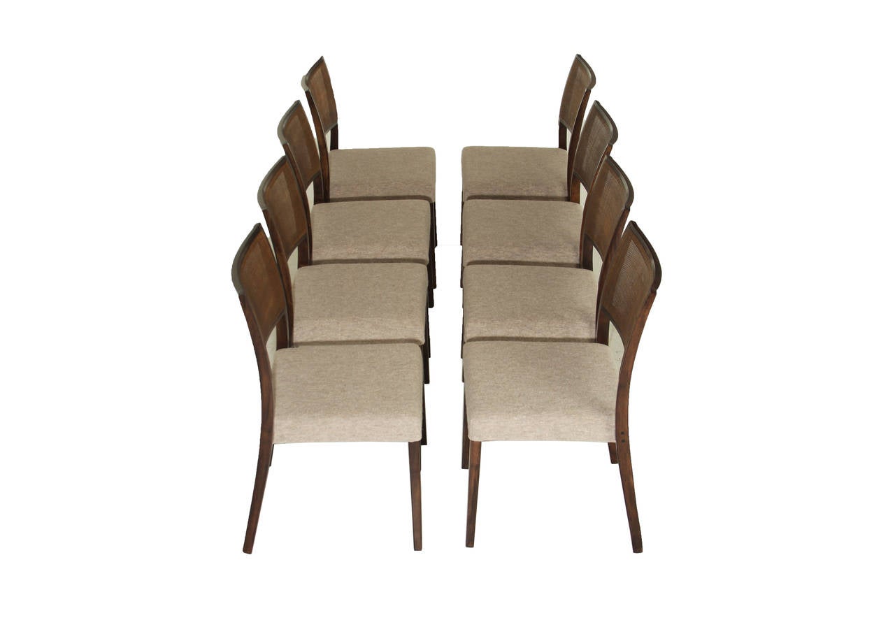 A sophisticated and sleek set of eight vintage dining chairs from Brazil with curved, caned backs and newly reupholstered seats in a boiled gray wool.

Seat measures 17.5