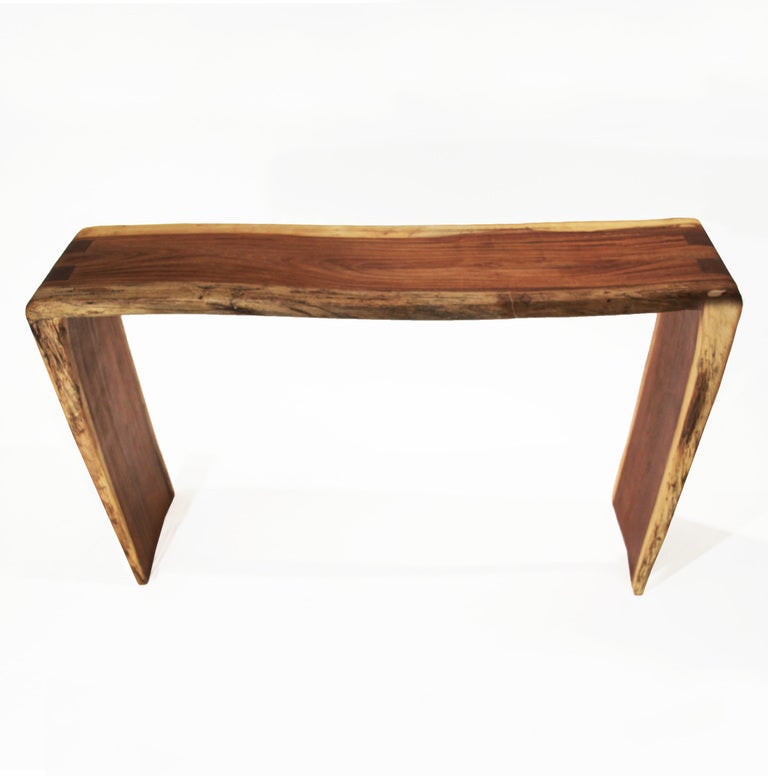 A one-of-a-kind sculptural solid Jatoba console table by Tunico T. The table has tapered, angled sides. Tunico T. lives in Brasilia with his wife and two of his children. He finds his raw materials in the surrounding a^Cerrado,a^ the largest