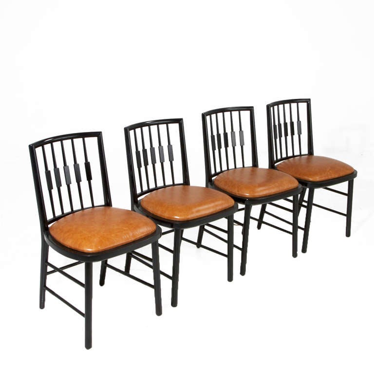 A set of black spindle back dining chairs by Baker with distressed caramel leather seats. 

Seat depth: 17