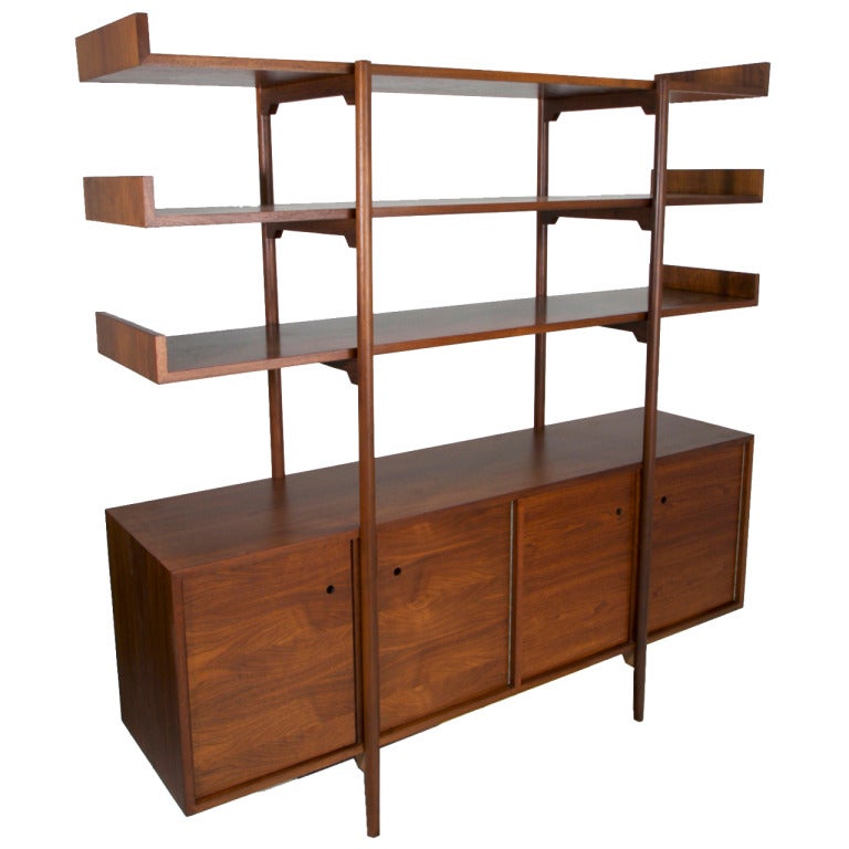 A rare and early Walnut credenza with 4 compartments and three bookshelves floating above it designed by Milo Baughman for Glenn of California. The credenza doors have small round finger holes for pulls and the three shelves have side lips to help