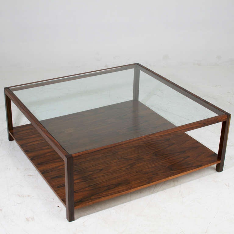 A beautiful custom square coffee table by Thomas Hayes Studio made of Rosewood with an inset glass top and single Rosewood shelf. 

Available for custom order and the lead time is 6-8 weeks; sometimes we are able to complete projects faster, so