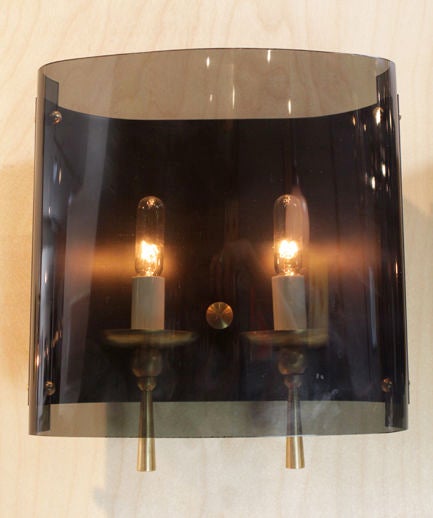 A beautiful pair of large wall sconces with brass fixtures for the bulbs, a dark glass backplate and a curved tinted glass shade in front fixed to the back with brass hardware.

In order to preserve our inventory, after restoration we blanket wrap