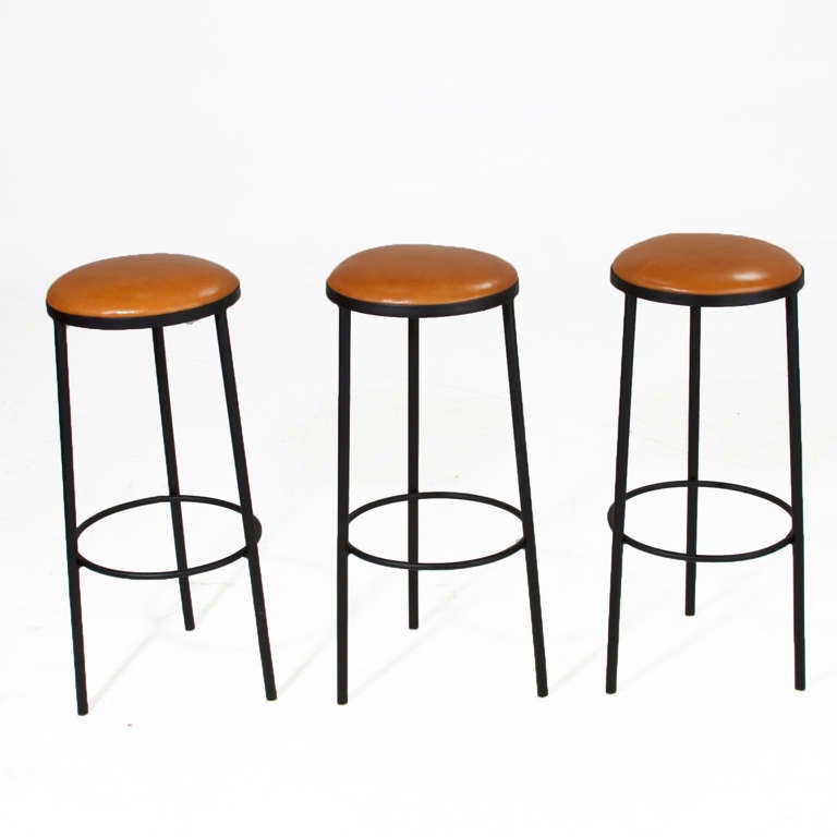 A set of 3 of vintage black iron frame round bar stools with inset leather seats. 

Many pieces are stored in our warehouse, so please click on CONTACT DEALER under our logo below to find out if the pieces you are interested in seeing are on the