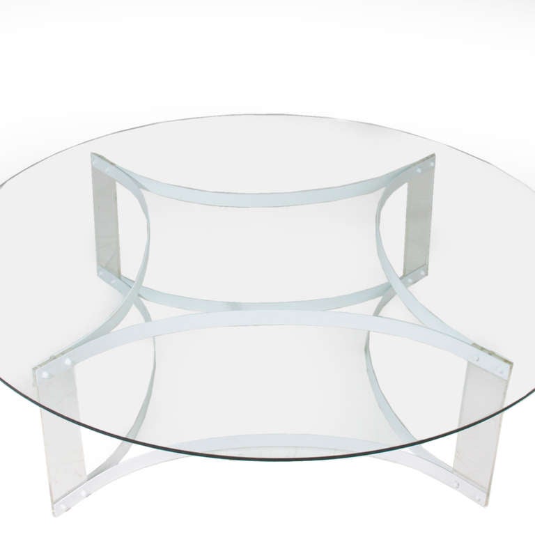 A round glass coffee table with a white finished steel star-shaped base. On each corner of the base there is Lucite that attaches the top of the base to the bottom. Lucite is in original condition and has significant marks, scuffs and wear