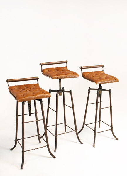 A lovely set of 3 curved bronze frame bar stools with tufted leather seats in a rich pale brown slightly distressed leather. The stools swivel and are adjustable in height - the main image shows them at different heights. They are completely made of