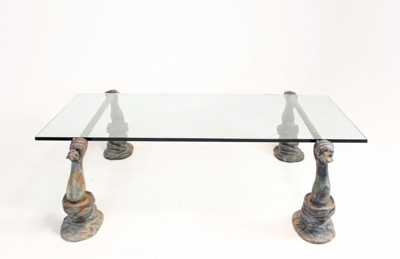 Coffee table with a glass top that sits on four sculptural bases in the shape of a fist. The bronze base has an incredible green patina and delicate pitting, indicating its age. We believe this is from the 1960's. EXTREMELY heavy.

Many pieces are