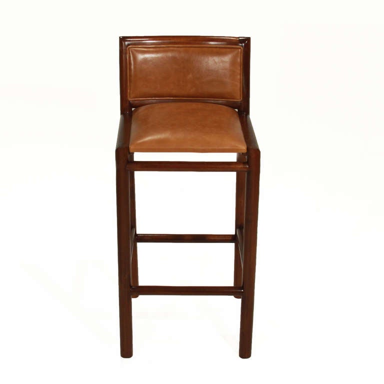 A pair of 2 solid wood bar stools by Celina that are upholstered in burnt caramel leather.  depth measures 14