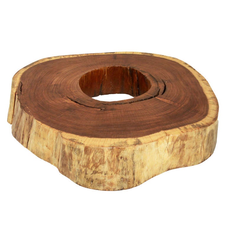 Tamboril round coffee table by Tunico T. The table has rollers that are concealed as they are recessed and shy. 

 Tunico T. lives in Brasilia with his wife and two of his children. He finds his raw materials in the surrounding Cerrado, the