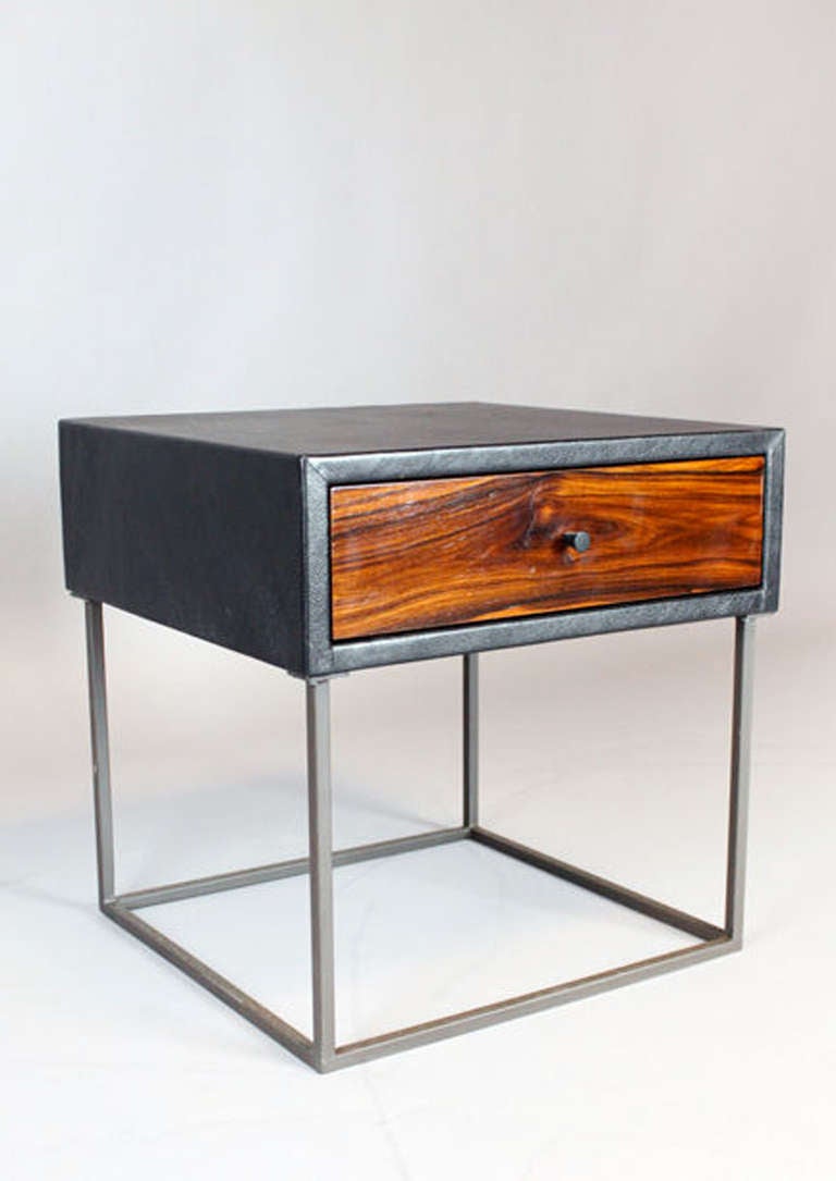 The Deane side table by Thomas Hayes Studio features a leather wrapped case with wood faced drawer on thin square solid steel or brass base, available for custom order. The single or double drawers are made with the highest quality soft-close