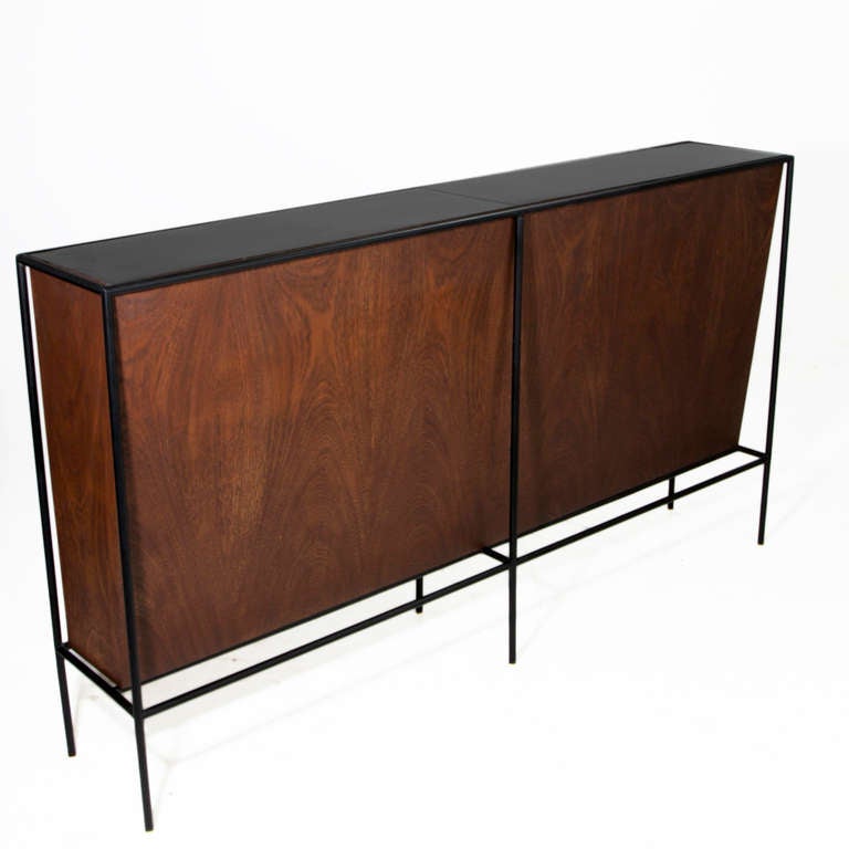 A unique bar designed by Brazilian designer Geraldo de Barros in exotic hardwood with black iron tube frame and black Formica top in 2 sections. 

A matching set of 3 stools is also available in another listing. 

Many pieces are stored in our
