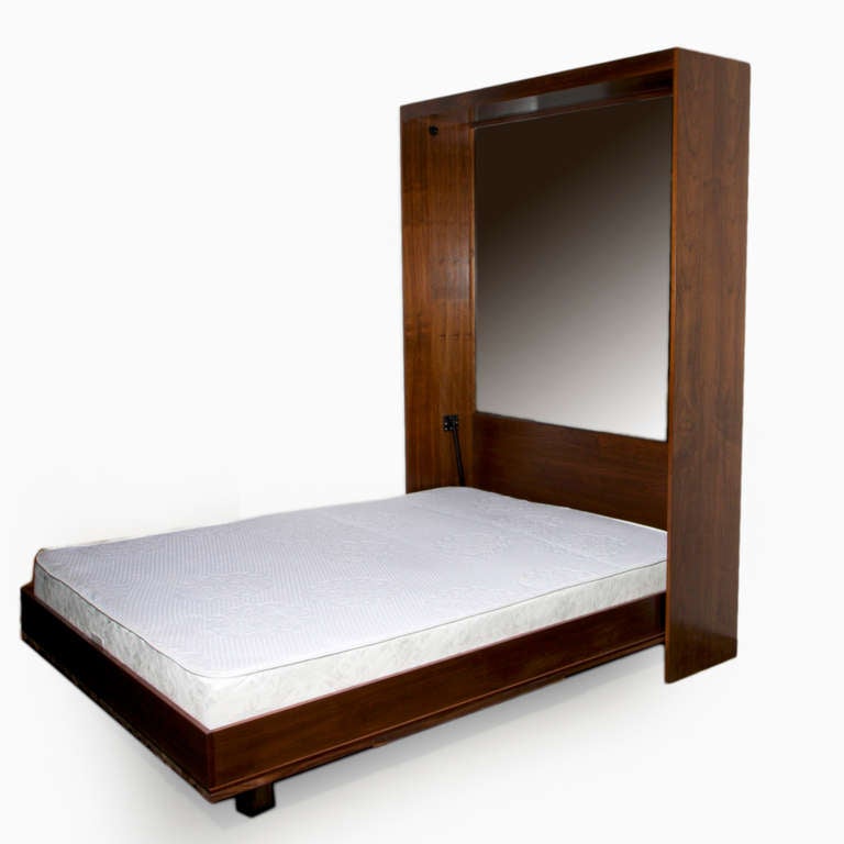 A patchwork solid Walnut Murphy bed with bronze tinted mirror front. When unfolded, the back headboard also has a bronze tinted mirror, and the supporting Walnut shelf that functions as the legs is also solid Walnut on the edges. There are LED