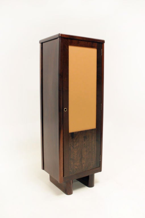 A unique Baruna wood locker from Brazil with an inset caramel leather door. The interior contains a hanging rod and small hooks.

Many pieces are stored in our warehouse, so please click on CONTACT DEALER under our logo below to find out if the