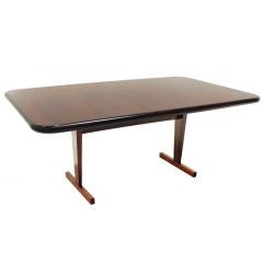 Rosewood dining table with angled feet and rounded corners
