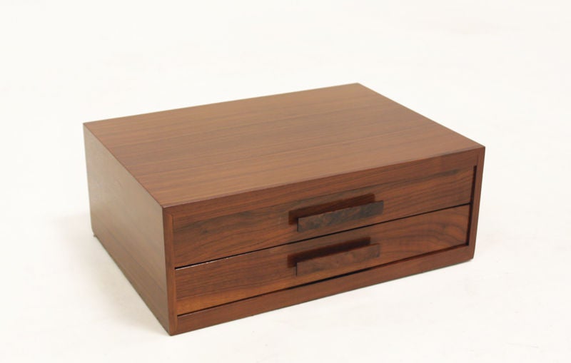 A jewelry or watch box in solid walnut with angled horizontal pulls. Possibly from the California Craftsman Revolutionary movement.  We have sold similar pieces by Glenn of California designed by John Kapel.
Many pieces are stored in our warehouse,