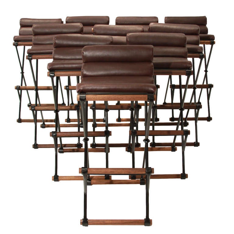 Curved seat bar stools with rolled leather seats, steel bases and solid walnut foot rests by Thomas Hayes Studio in the style of Cleo Baldon. 

This item is available for custom order and the lead time is 6-8 weeks; sometimes we are able to