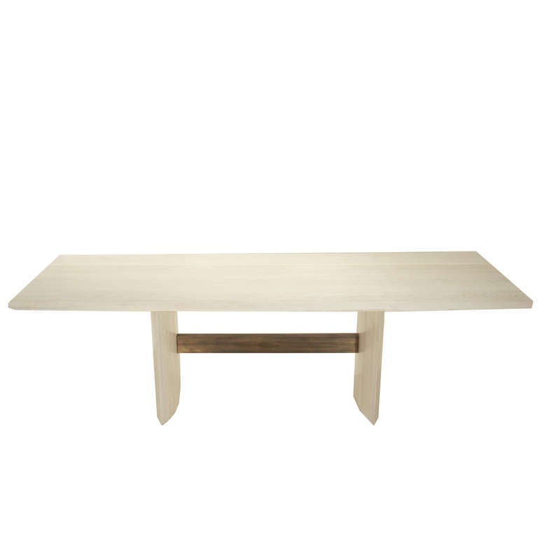 A solid bleached Oak dining table by Thomas Hayes Studio, with the stretcher made of the highest grade archetectural bronze. Legs are made of solid stacked laminate Oak and are eye shaped. 

This particular table is in Solid Bleached Oak. This
