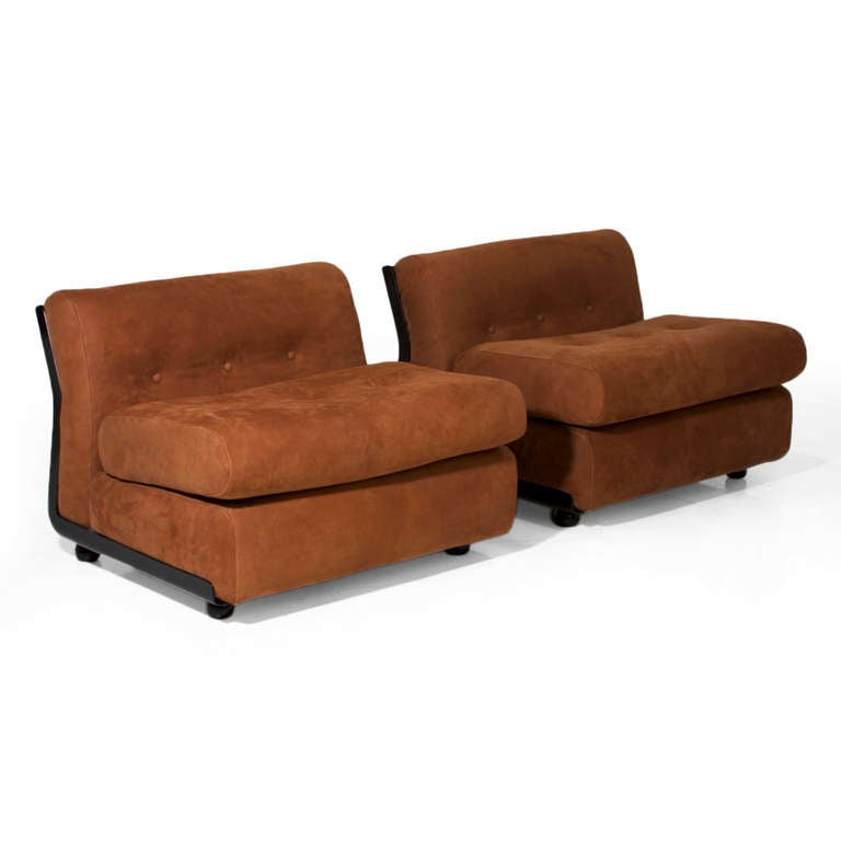 A pair of slipper chairs or lounge chairs in tufted brown suede with a curved ebonized fiberglass back and rounded feet.

Seat depth measures 20