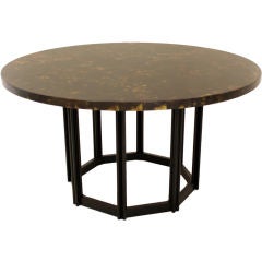 Round dining table with patinated metal top.