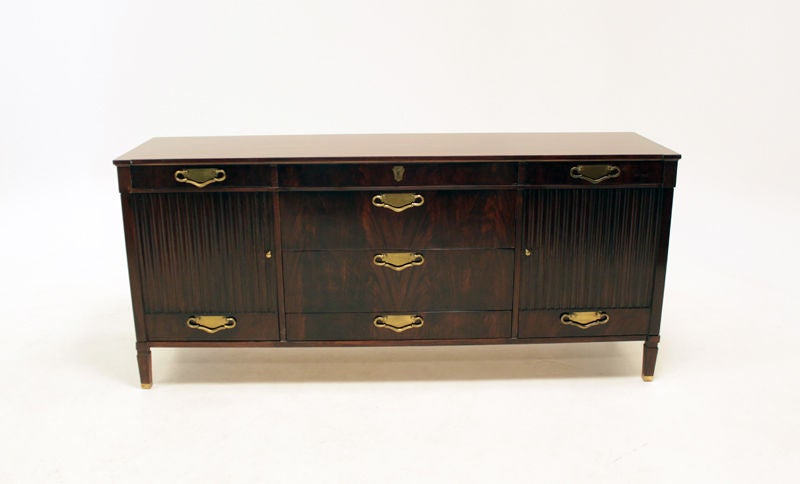 A gorgeous dark walnut credenza with elegant brass handle accents. Doors open to reveal shelving and drawers in the interior.

Many pieces are stored in our warehouse, so please click on CONTACT DEALER under our logo below to find out if the