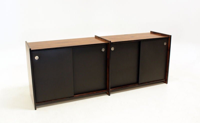 A rich rosewood credenza with beautiful butterfly sap grain and round, inset chrome finger pulls. Four sliding doors are wrapped in a supple black leather.

