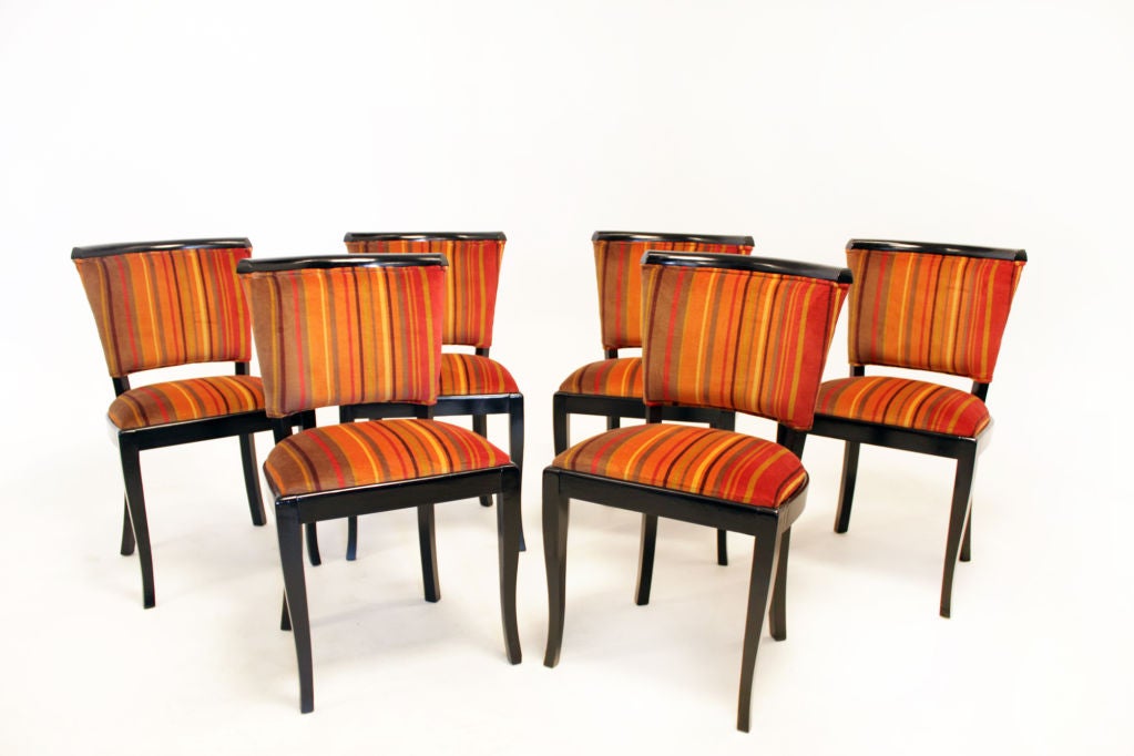 A set of six dining chairs with ebonized wood frames and upholstered in an orange and red striped mohair fabric.

Measures: Seat depth 17.5