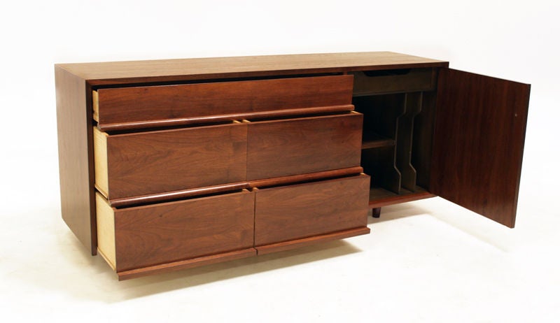 A Walnut cabinet with five drawers and single door with a round wood pull. Door opens to reveal shelving inside. See separate listing with similar cabinet for a matched set.

Many pieces are stored in our warehouse, so please click on contact