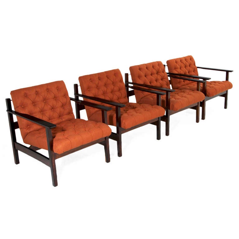 A beautiful set of four Brazilian lounge chairs in solid Rosewood. The Rosewood has been refinished in a natural satin lacquer and the orange tufted fabric has been newly upholstered. 

A matching sofa is also available in another listing.