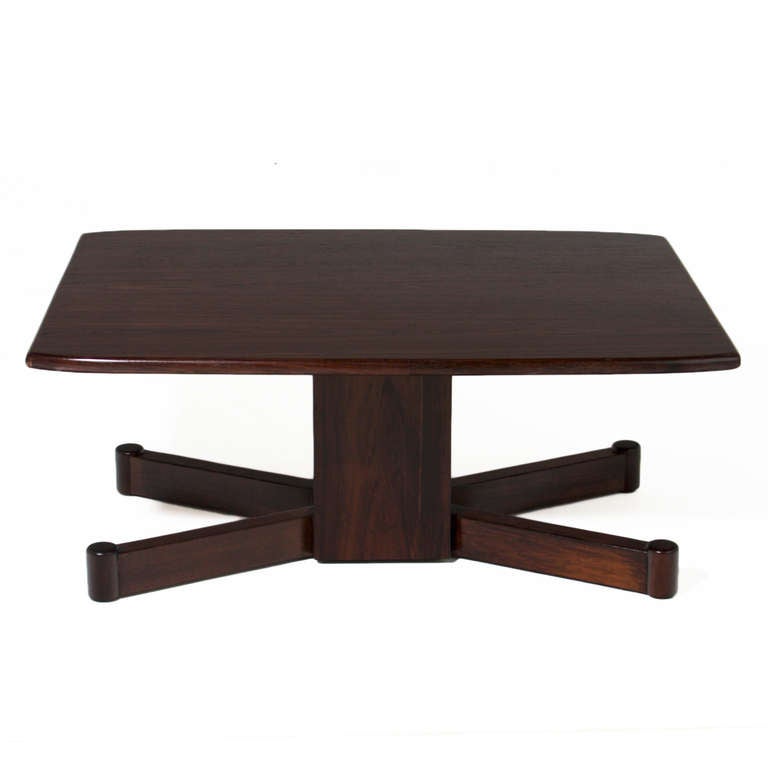 A beautiful Brazilian exotic hardwood coffee table. The base has a solid beam with two V-shaped feet that have a cylindrical shape at the tips.

 