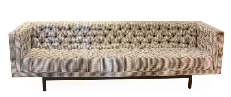 A lovely vintage sofa microtufted in black and white houndstooth fabric with black leather buttons and flat  black finished metal base.
Seat depth measures 22
