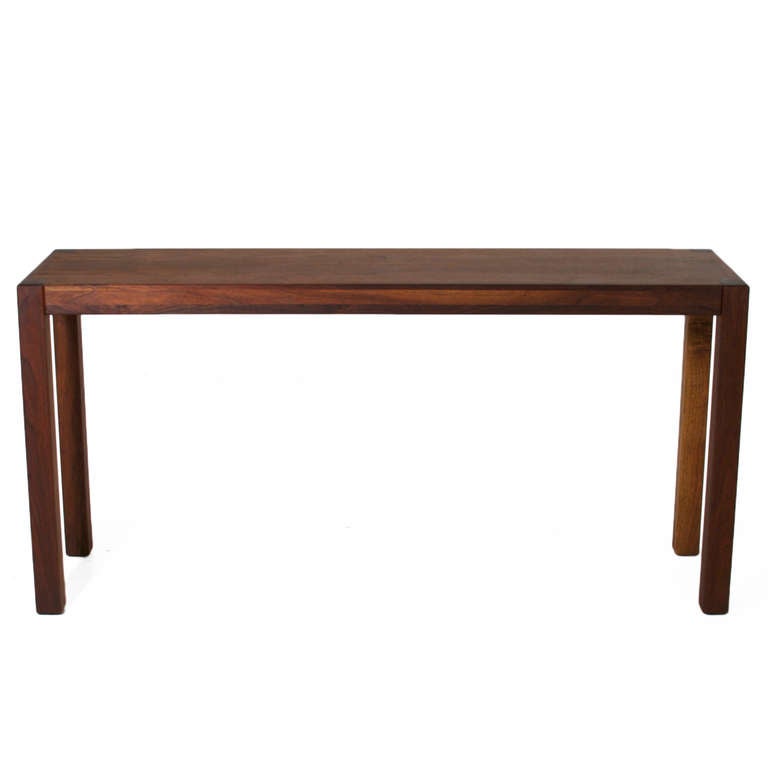 An elegant Walnut Console in an oil finish that feels satin smooth but looks like raw wood. The top has a prominent lighter grain, and the legs are darker, creating a nice contrast. 

Many pieces are stored in our warehouse, so please click on