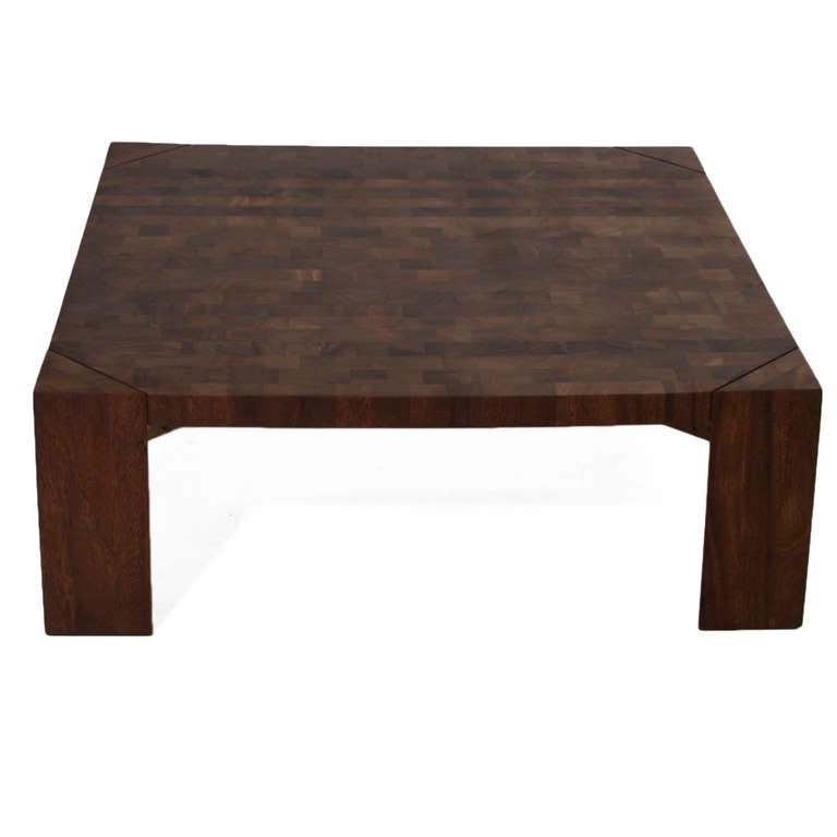 A parquetry solid Mahogany wood coffee table with angular legs designed by noted California designer Sherrill Broudy. Sherrill Broudy was one of the founders and owners of Panelcarve, which became Forms + Surfaces. This coffee table is part of a