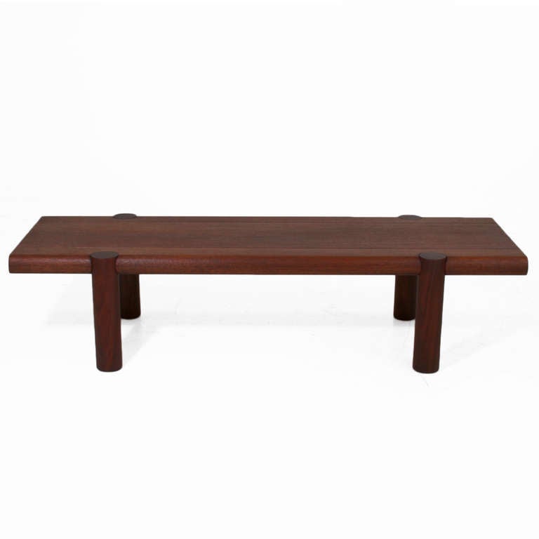 A lovely solid exotic hardwood bench with rounded edges and round solid exotic hardwood legs by noted California designer Sherrill Broudy. The bench can be used as a coffee table as well, and as 2 long pin stripe cut outs along the top edge. The