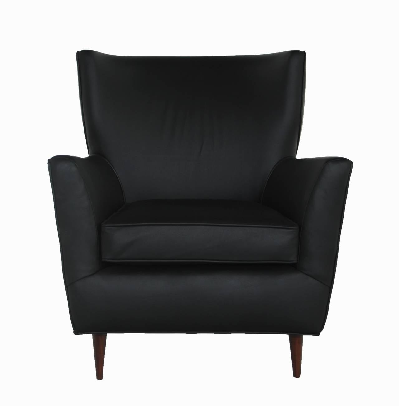 A single armchair by Joaquim Tenreiro upholstered in black leather with slender lathed wood legs.


In order to preserve our inventory, after restoration we blanket wrap and store nearly every piece in our warehouse.  Please email Hayes Gallery in