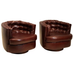 Pair of leather tufted barrel swivel chairs by Milo Baughman