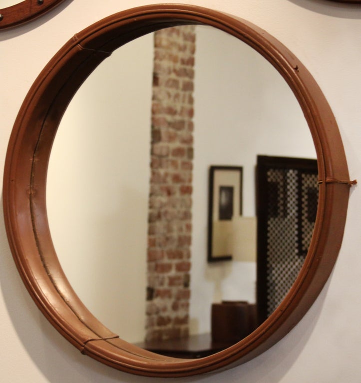 Large round mirror with a distressed caramel leather wrapped frame designed by Jorge Zalszupin for L'atelier. The front edge has a piping detail and there are 3 seams around the edges.
Many pieces are stored in our warehouse, so please give us a