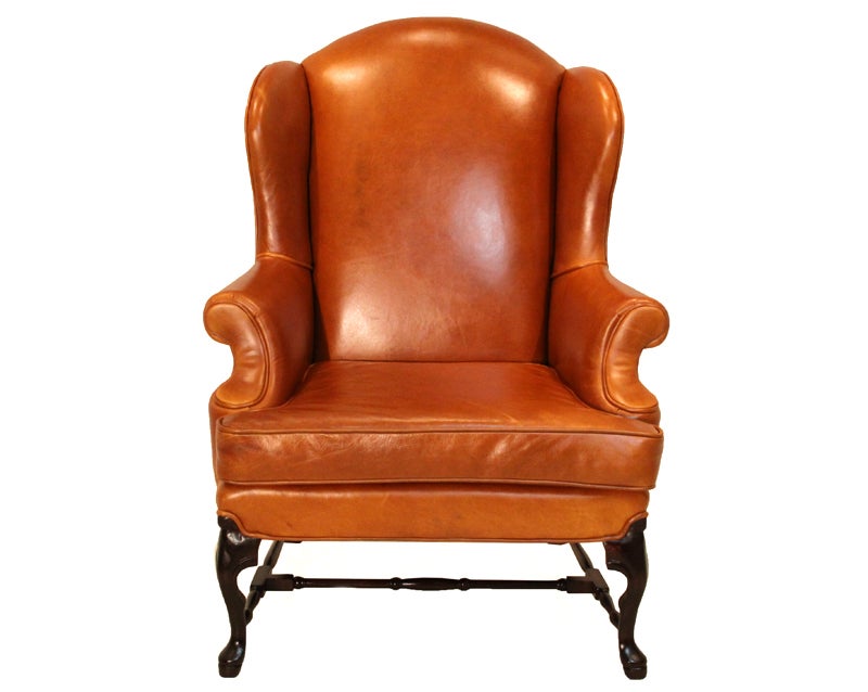 Pair of large scale leather wing back chairs re-upholstered in a caramel leather. The chairs feature a pair of cabriole legs in front and curved back legs connected by a sculptural stretcher.'
Seat depth 21.5