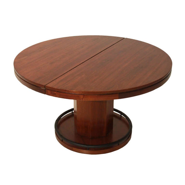 A  Walnut round dining table with eight inserts to create an octogon poker table. The inserts each have elegantly carved chip and drink holders. There is also a center leaf to extend the dining table on either side and the center pedestal is