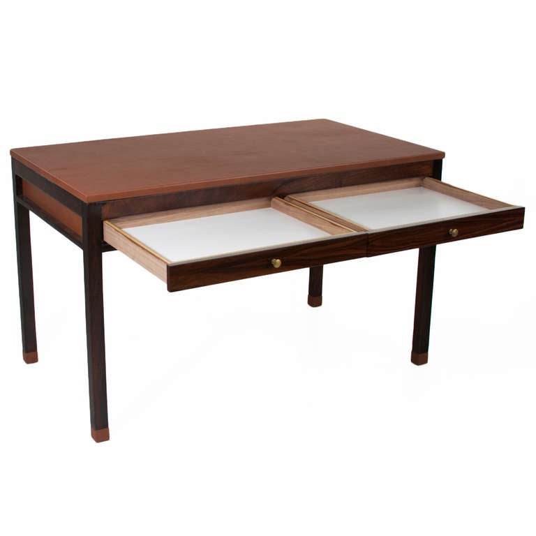 A stunning Brazilian desk with a tan leather wrapped top and matching leather tips on all four legs. The desk has beautiful leather cut outs on the sides and back of the desk. The knobs are patinated brass and are original. 

In order to preserve