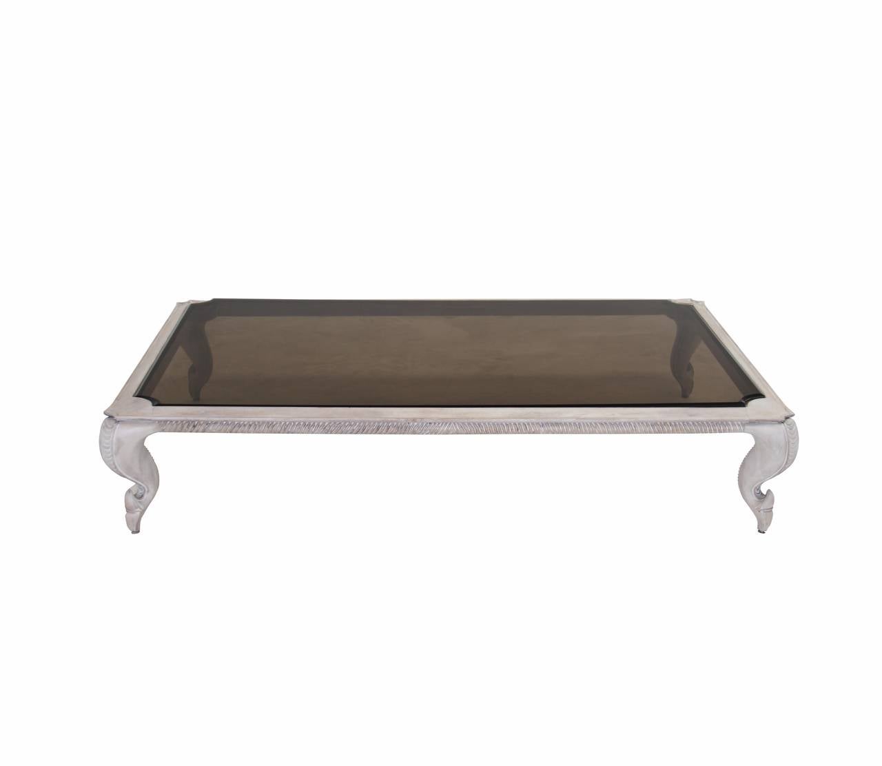 A rectangular coffee table in a bleached solid carved walnut with white oil finish. Smoky black glass top is a thick double laminated piece. 

 