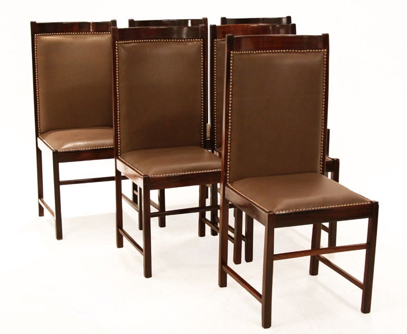 Set of six beautiful high back chairs by Celina Moevis made with solid rosewood and a high quality supple brown leather. There are bronze tacks that surround the leather seats and backs. 
Seat depth 16

Many pieces are stored in our warehouse, so