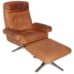 Swiveling caramel leather armchair and ottoman by De Sede