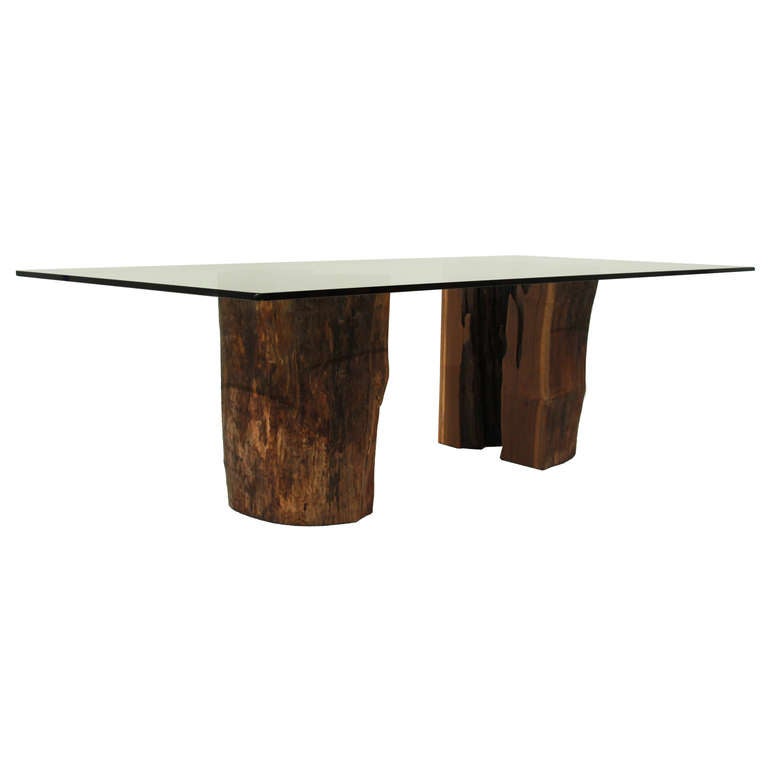A halved Ipe stump pedestal dining table with a glass top by Tunico T. The design allows for a view into the interior of the hollowed tree. Tunico T. lives in Brasilia with his wife and two of his children. He finds his raw materials in the