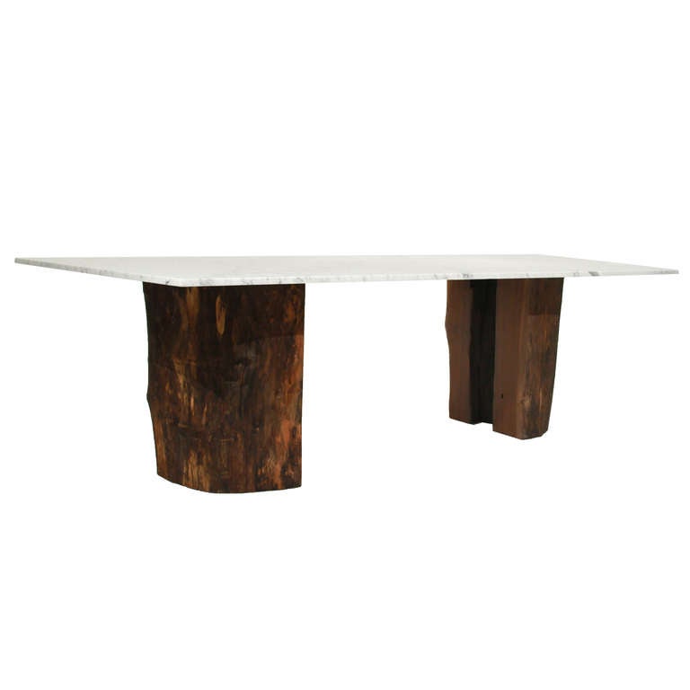 A halved Ipe stump pedestal dining table with a marble top by Tunico T. The design allows for a view into the interior of the hollowed tree. Tunico T. lives in Brasilia with his wife and two of his children. He finds his raw materials in the
