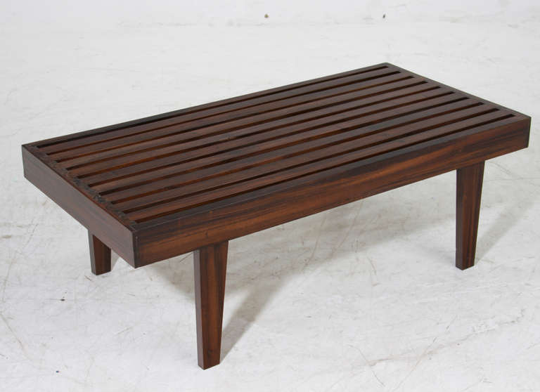 A solid Brazilian exotic hardwood coffee table with slatted top and slightly splayed legs.

 