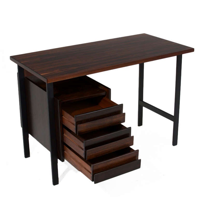 A petite Brazilian Hardwood desk with beautiful grain on top with a few blonde saps. The legs are flat black finished metal and the drawers have solid rosewood pulls.

Many pieces are stored in our warehouse, so please click on “CONTACT DEALER”